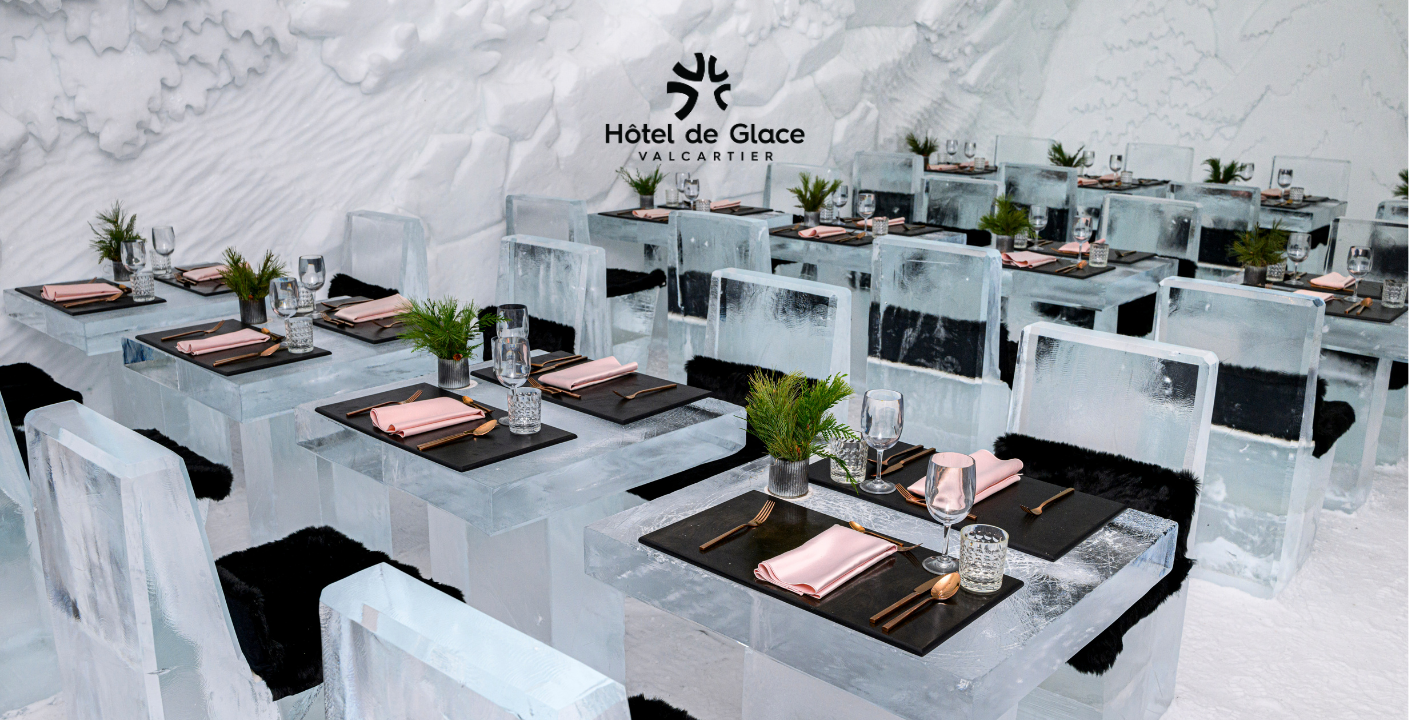 La salle à manger du restaurant de glace donne l’impression d’entrer dans une véritable cathédrale nordique, entièrement façonnée dans la neige et la glace. Les murs, délicatement sculptés de motifs forestiers et de paysages hivernaux, enveloppent l’espace d’une blancheur apaisante, réchauffée par un éclairage doux et bien pensé. Les tables et les chaises, taillées dans des blocs de glace cristalline, sont habillées de surfaces mates et de peaux de fourrure